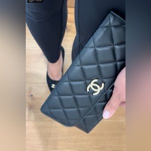 CHANEL Quilted Black Clutch with Gold Emblem